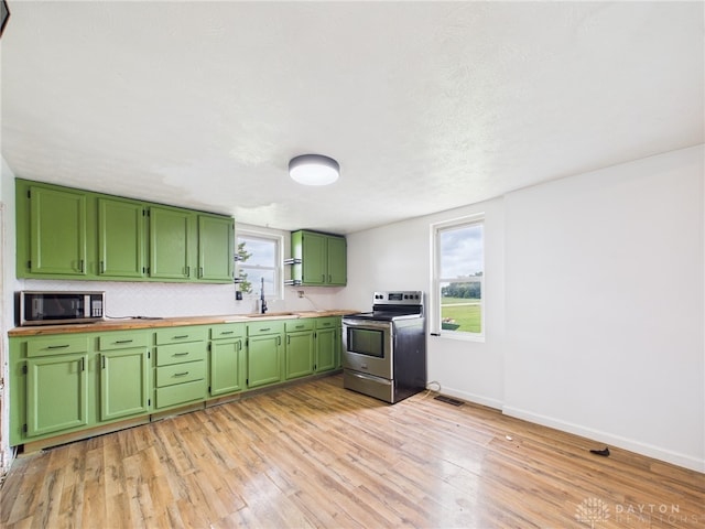 491 Frazers Rd, West Manchester, OH 45382 - kitchen with stainless steel appliances, green cabinetry, light wood-type flooring, and tasteful backsplash