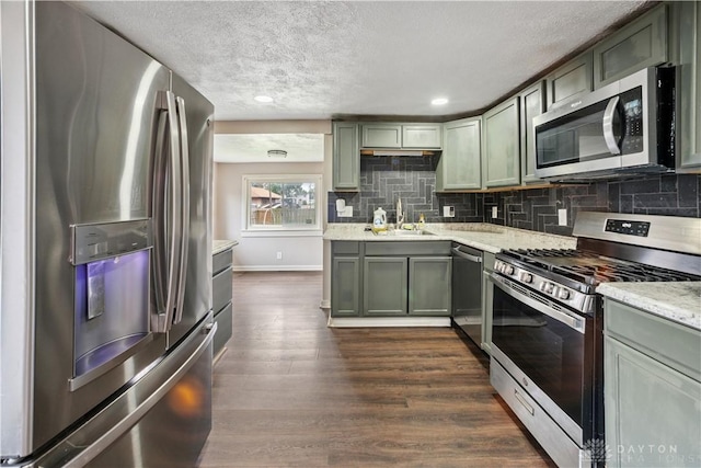 3579 Alberta St, Columbus, OH 43228 - kitchen featuring appliances with stainless steel finishes, dark wood-style floors, a textured ceiling, tasteful backsplash, and green cabinets