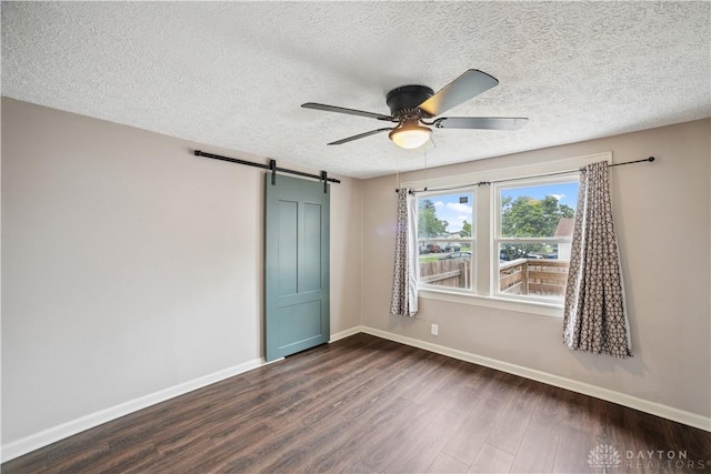 3579 Alberta St, Columbus, OH 43228 - spare room featuring dark wood finished floors, ceiling fan, a textured ceiling, and a barn door