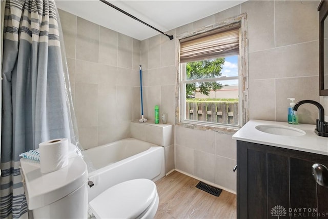 3579 Alberta St, Columbus, OH 43228 - bathroom with tile walls, wood finished floors, vanity, and shower / tub combo with curtain