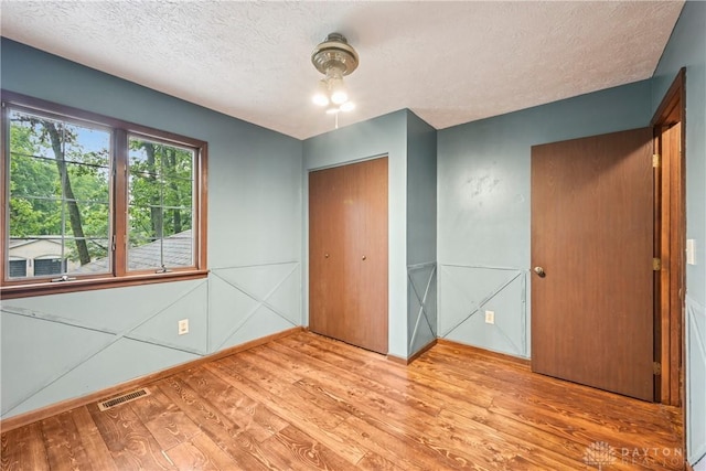 4595 Comanchee Trl, Silver Creek Twp, OH 45335 - unfurnished bedroom featuring wood finished floors, a textured ceiling, and a closet