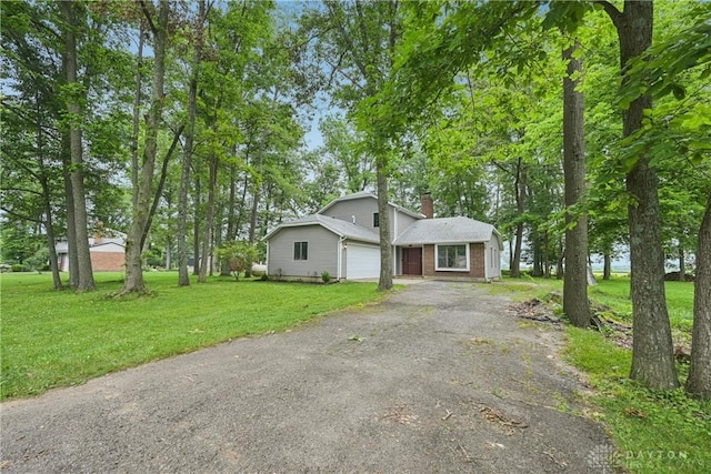 4595 Comanchee Trl, Silver Creek Twp, OH 45335 - view of front facade with driveway, a front lawn, a chimney, and a garage