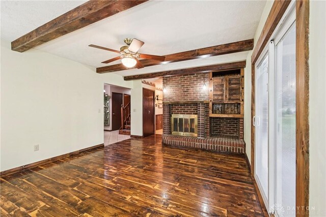 4595 Comanchee Trl, Silver Creek Twp, OH 45335 - unfurnished living room with wood-type flooring, beam ceiling, a ceiling fan, and a brick fireplace
