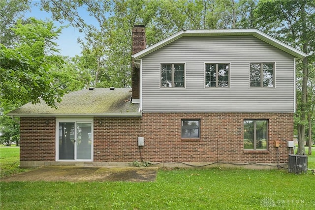 4595 Comanchee Trl, Silver Creek Twp, OH 45335 - rear view of house with a chimney, a lawn, and brick siding