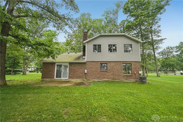 4595 Comanchee Trl, Silver Creek Twp, OH 45335 - back of house featuring a chimney, brick siding, a yard, and a patio