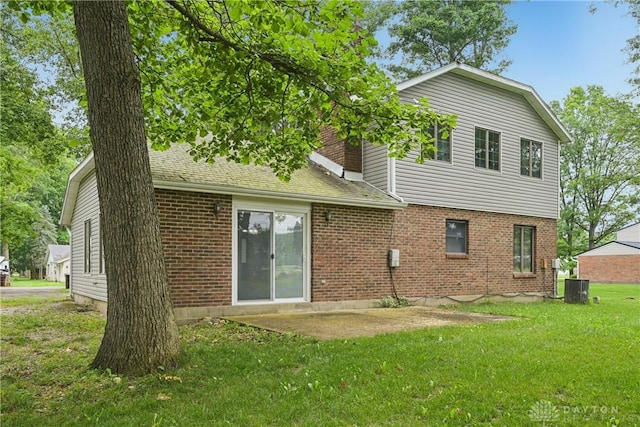 4595 Comanchee Trl, Silver Creek Twp, OH 45335 - rear view of property with brick siding, a lawn, and a patio area