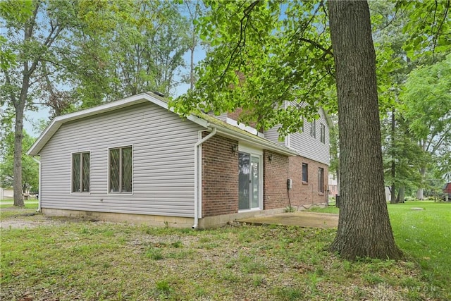 4595 Comanchee Trl, Silver Creek Twp, OH 45335 - view of home's exterior featuring a patio area, a yard, and brick siding