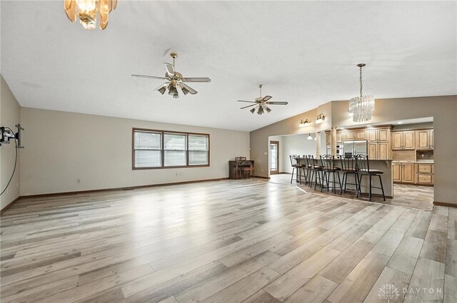 51 Jill Dr, Germantown, OH 45327 - living room with vaulted ceiling, light wood finished floors, a ceiling fan, and a chandelier