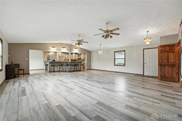 51 Jill Dr, Germantown, OH 45327 - living area with vaulted ceiling, light wood-type flooring, ceiling fan, and a chandelier