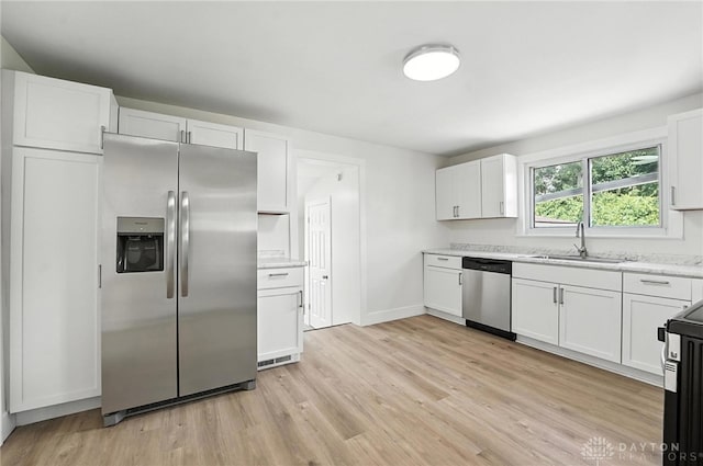 804 S Walnut St, Troy, OH 45373 - kitchen featuring stainless steel appliances, light wood finished floors, white cabinets, and light stone countertops