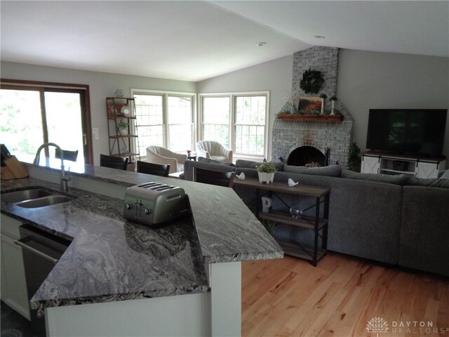12071 Oxford Rd, Germantown, OH 45327 - kitchen featuring vaulted ceiling, healthy amount of natural light, light wood-type flooring, stone countertops, and open floor plan