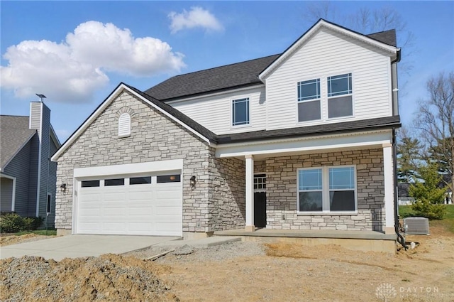 3384 Randall Dr, Cedarville Twp, OH 45314 - traditional-style home featuring stone siding, driveway, a porch, and an attached garage