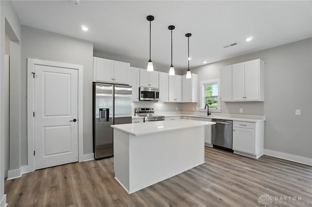 3384 Randall Dr, Cedarville Twp, OH 45314 - kitchen with appliances with stainless steel finishes, wood finished floors, white cabinetry, light countertops, and recessed lighting