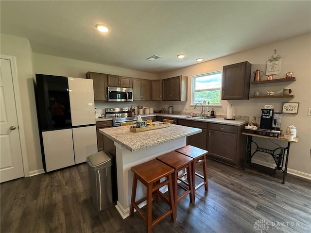 562 Maxwell Ct, Germantown, OH 45327 - kitchen with appliances with stainless steel finishes, dark wood finished floors, dark brown cabinets, light countertops, and a kitchen island