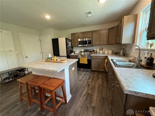 562 Maxwell Ct, Germantown, OH 45327 - kitchen featuring stainless steel appliances, dark wood-style floors, a breakfast bar area, a kitchen island, and recessed lighting