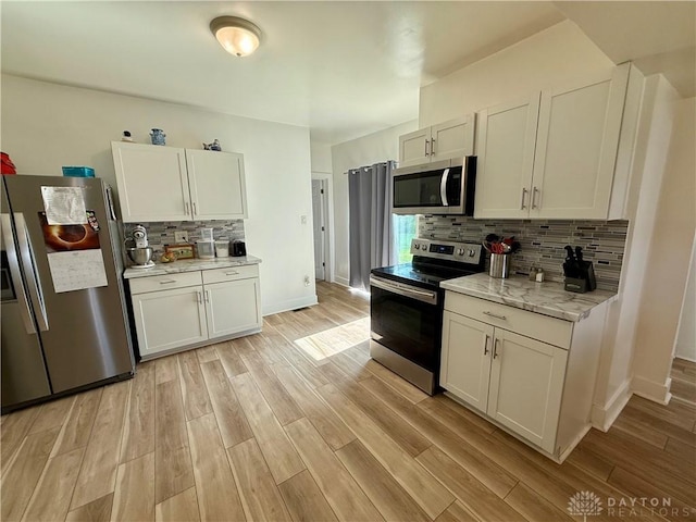 10995 Rockridge Rd, Lewisburg, OH 45338 - kitchen featuring stainless steel appliances, tasteful backsplash, light wood-style floors, white cabinets, and light stone counters