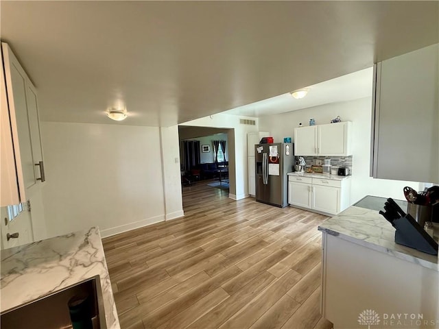10995 Rockridge Rd, Lewisburg, OH 45338 - kitchen with stainless steel fridge with ice dispenser, light wood finished floors, white cabinetry, decorative backsplash, and light stone countertops