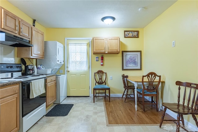 2701 Mini Ct, Dayton, OH 45420 - kitchen with under cabinet range hood, electric range oven, stacked washer / drying machine, light floors, and dark countertops