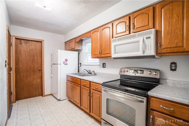 4267 W Wenger Rd, Clayton, OH 45315 - kitchen with white appliances, light countertops, light flooring, and brown cabinets