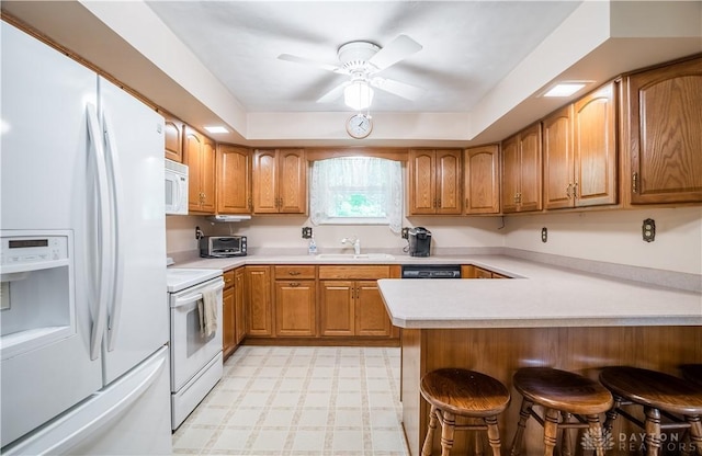 4267 W Wenger Rd, Clayton, OH 45315 - kitchen featuring white appliances, a kitchen breakfast bar, brown cabinetry, light countertops, and ceiling fan