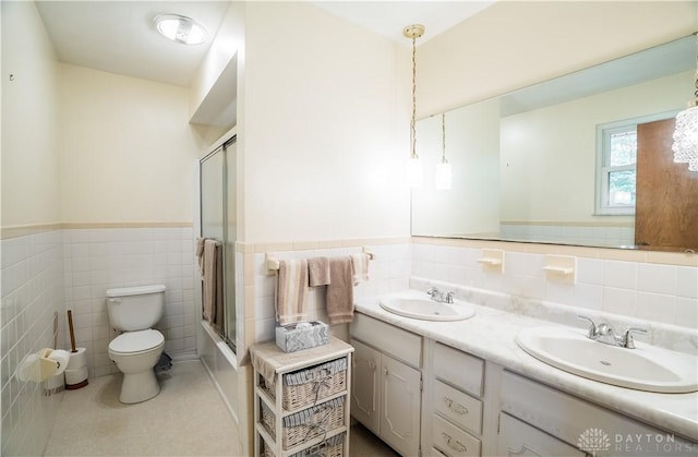 4267 W Wenger Rd, Clayton, OH 45315 - full bathroom featuring tile walls, double vanity, a wainscoted wall, shower / bath combination with glass door, and tile patterned floors