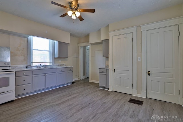 15 Bertus St, Cincinnati, OH 45217 - kitchen featuring gray cabinets, white electric stove, and light wood-type flooring