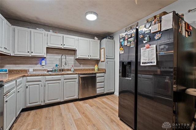 1227 Fyffe Ave, New Carlisle, OH 45344 - kitchen with black appliances, light wood-style flooring, and white cabinets