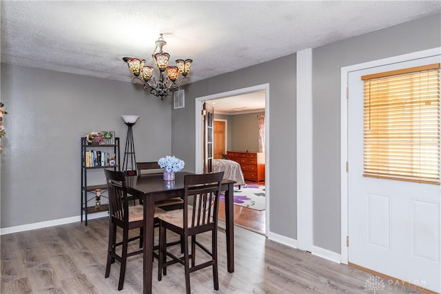 1221 Highview Dr, Fairborn, OH 45324 - dining area with a chandelier, wood finished floors, and a textured ceiling