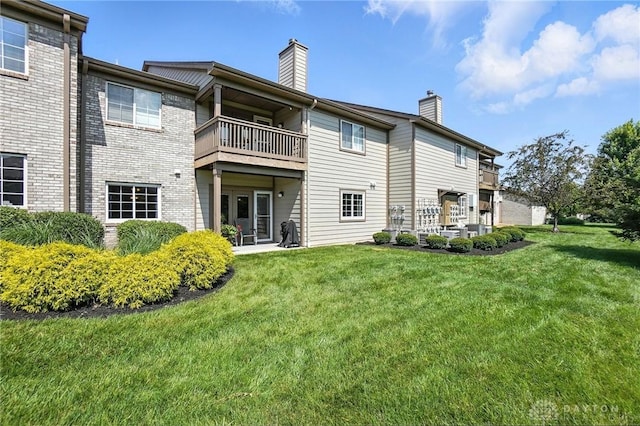 1720 Piper Ln Unit 104, Centerville, OH 45440 - rear view of property with a chimney, a balcony, a lawn, and brick siding
