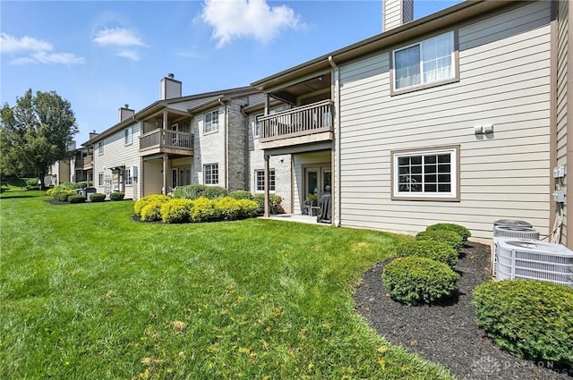1720 Piper Ln Unit 104, Centerville, OH 45440 - back of house with a chimney, a yard, and a balcony