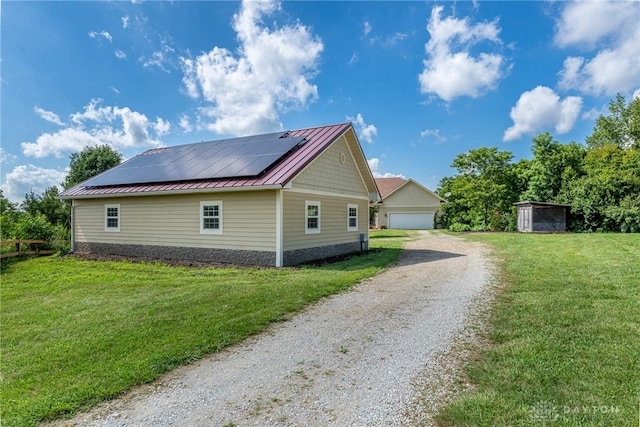 1590 Fairground Rd, Xenia, OH 45385 - view of side of home with an outbuilding, roof mounted solar panels, a standing seam roof, a metal roof, and a lawn