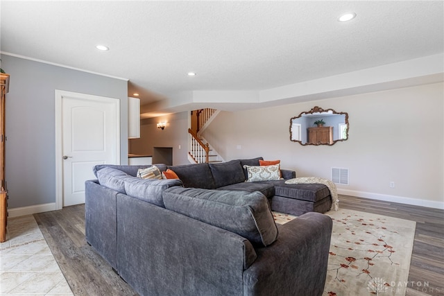 1590 Fairground Rd, Xenia, OH 45385 - living area featuring stairs, recessed lighting, light wood finished floors, a textured ceiling, and ornamental molding
