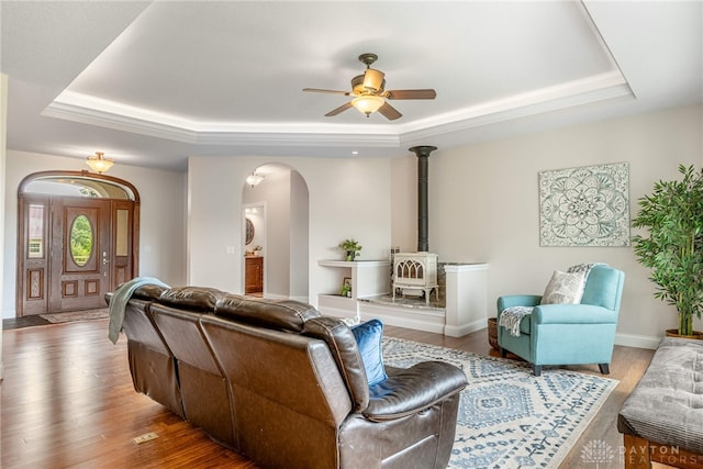 1590 Fairground Rd, Xenia, OH 45385 - living room featuring a tray ceiling, a wood stove, and arched walkways