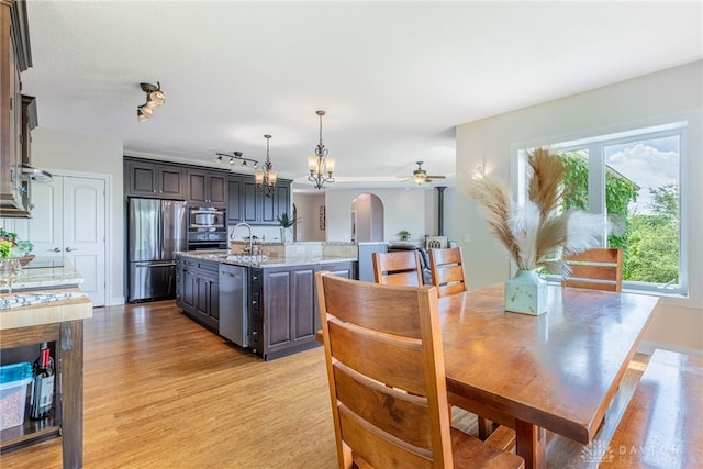 1590 Fairground Rd, Xenia, OH 45385 - dining space featuring light wood-type flooring, a ceiling fan, arched walkways, and a chandelier
