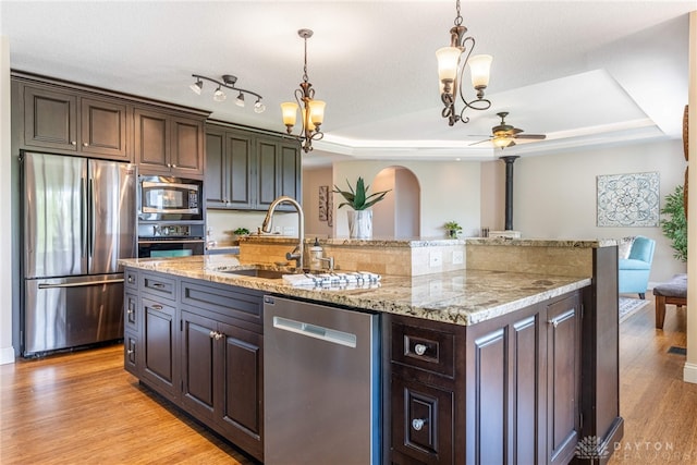 1590 Fairground Rd, Xenia, OH 45385 - kitchen with appliances with stainless steel finishes, a raised ceiling, light wood finished floors, ceiling fan, and a kitchen island with sink