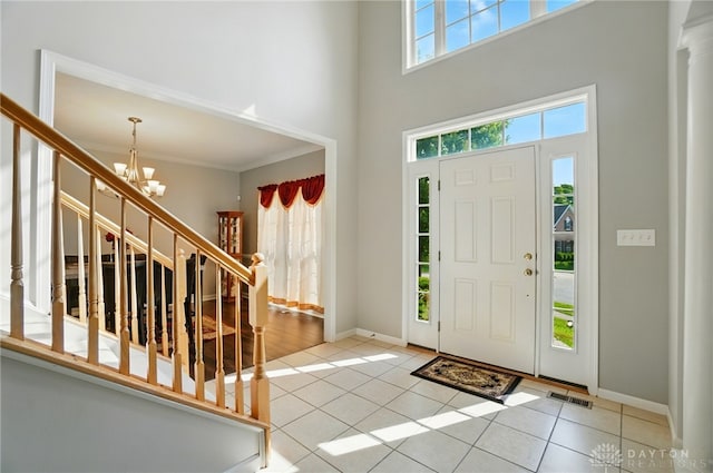 2435 Forest Oaks Dr, Beavercreek, OH 45431 - foyer entrance featuring stairs, a chandelier, tile patterned floors, a towering ceiling, and crown molding