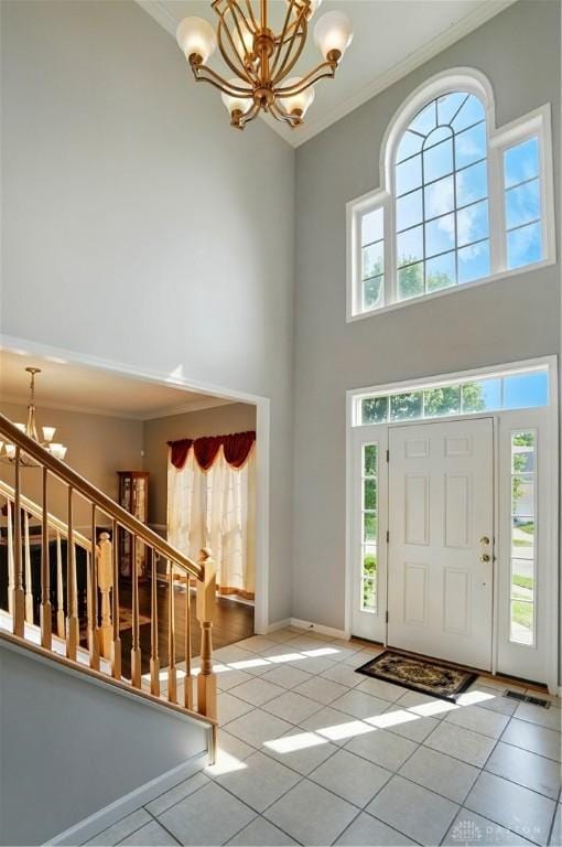 2435 Forest Oaks Dr, Beavercreek, OH 45431 - foyer featuring a chandelier, crown molding, a towering ceiling, tile patterned flooring, and stairs