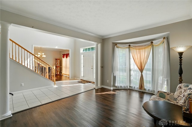 2435 Forest Oaks Dr, Beavercreek, OH 45431 - tiled entrance foyer featuring ornate columns, crown molding, stairway, and a chandelier