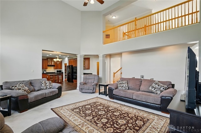 2435 Forest Oaks Dr, Beavercreek, OH 45431 - living area featuring ornate columns, ceiling fan, a chandelier, a high ceiling, and stairway