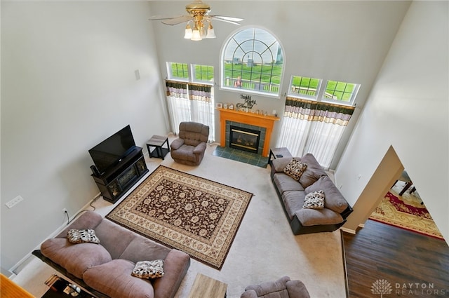 2435 Forest Oaks Dr, Beavercreek, OH 45431 - living area featuring a towering ceiling, a ceiling fan, a tile fireplace, and wood finished floors
