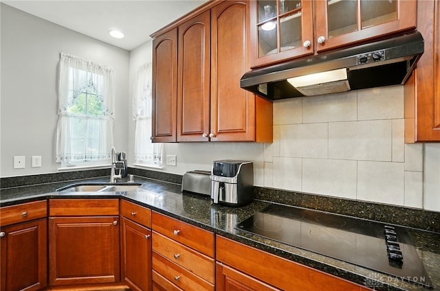 2435 Forest Oaks Dr, Beavercreek, OH 45431 - kitchen featuring black electric stovetop, under cabinet range hood, dark stone counters, glass insert cabinets, and backsplash