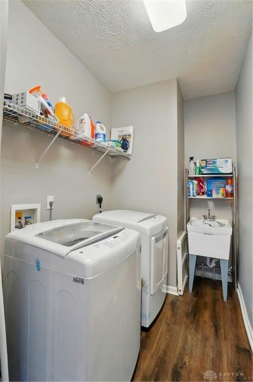 2435 Forest Oaks Dr, Beavercreek, OH 45431 - washroom featuring washing machine and dryer, dark wood-type flooring, and a textured ceiling