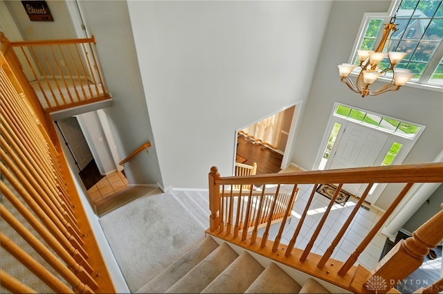 2435 Forest Oaks Dr, Beavercreek, OH 45431 - stairway featuring a high ceiling and a chandelier