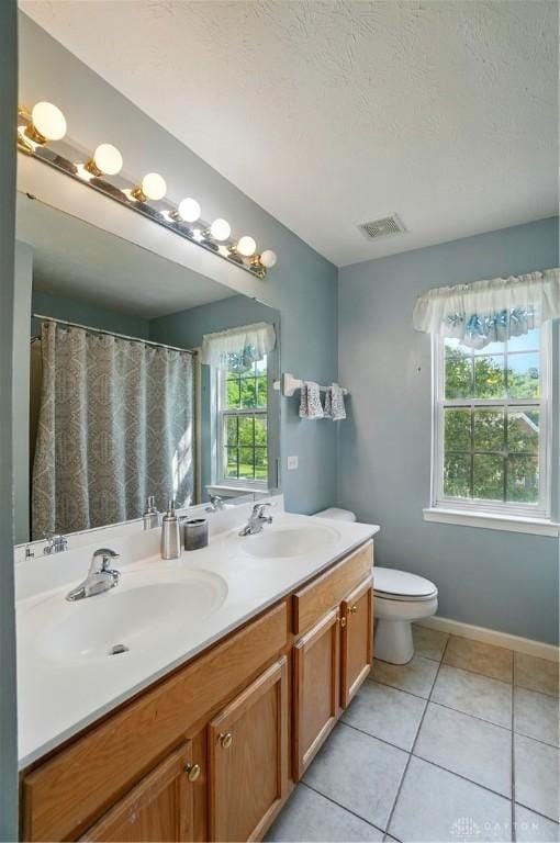 2435 Forest Oaks Dr, Beavercreek, OH 45431 - bathroom with double vanity, tile patterned flooring, and a textured ceiling