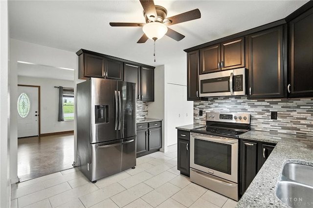 5 Bayberry Dr, Springboro, OH 45066 - kitchen with stainless steel appliances, a ceiling fan, decorative backsplash, light stone countertops, and light tile patterned floors
