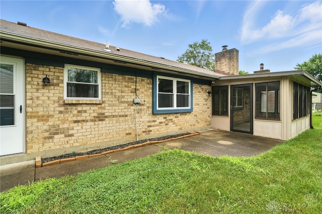 5 Bayberry Dr, Springboro, OH 45066 - rear view of house with a chimney, a sunroom, a lawn, a patio area, and brick siding