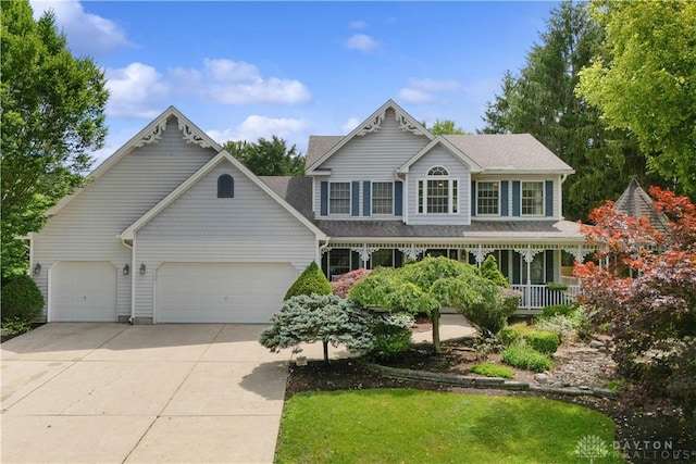 395 Victoria Pl, Waynesville, OH 45068 - victorian home featuring an attached garage, concrete driveway, and covered porch