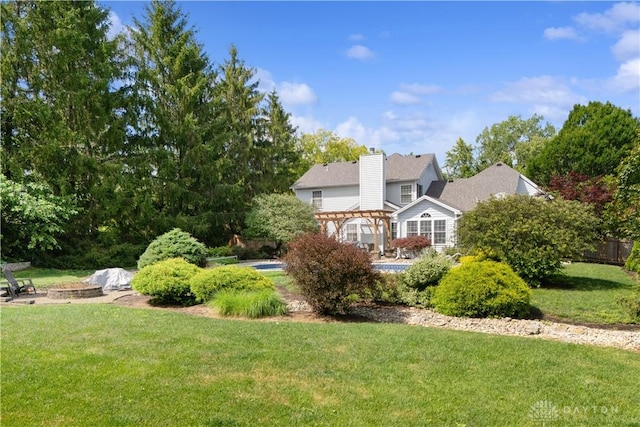 395 Victoria Pl, Waynesville, OH 45068 - rear view of house with a pergola, a yard, and a chimney