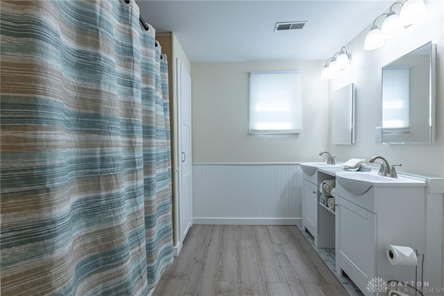 989 Ogden Rd, Adams Twp, OH 45177 - full bath with wood finished floors, two vanities, and wainscoting