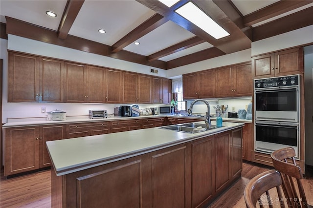 11 Peterson Pl, Wilmington, OH 45177 - kitchen with wood finished floors, beamed ceiling, light countertops, a center island with sink, and recessed lighting